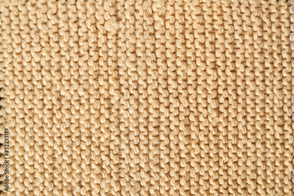 Knitted texture in beige macro with a handkerchief technique Knitted texture in beige macro with a handkerchief technique