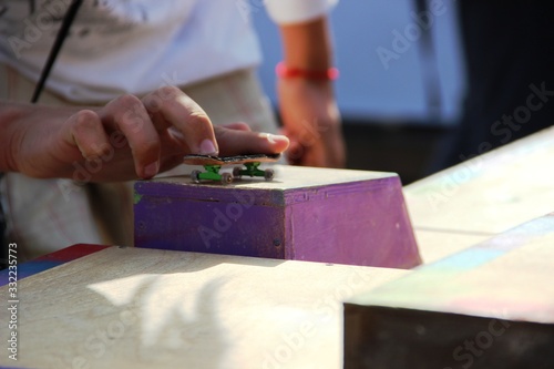 teens hand playing the fingerboard. fingerboard competitions, freestyle and hurdles.