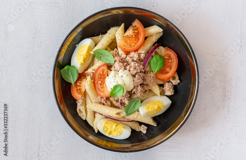 Fotografie Tuna salad with pasta, tomato, egg in a bowl