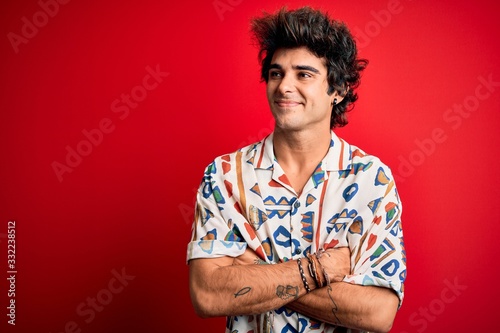 Canvas Print Young handsome man on vacation wearing summer shirt over isolated red background