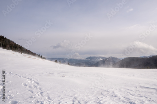 Snow covered meadow in the mountains with mountains in the background and a beautiful arch, Slovakia Mala Fatra © Martin