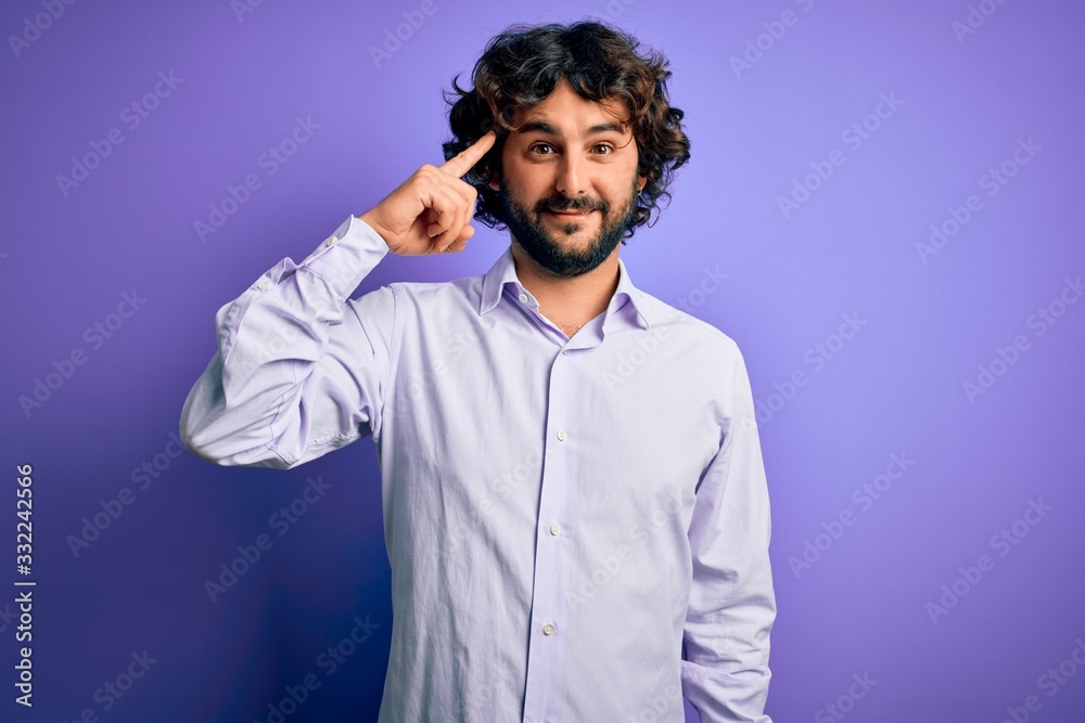 Young handsome business man with beard wearing shirt standing over purple background Smiling pointing to head with one finger, great idea or thought, good memory Young handsome business man with beard wearing shirt standing over purple background Smiling pointing to head with one finger, great idea or thought, good memory
