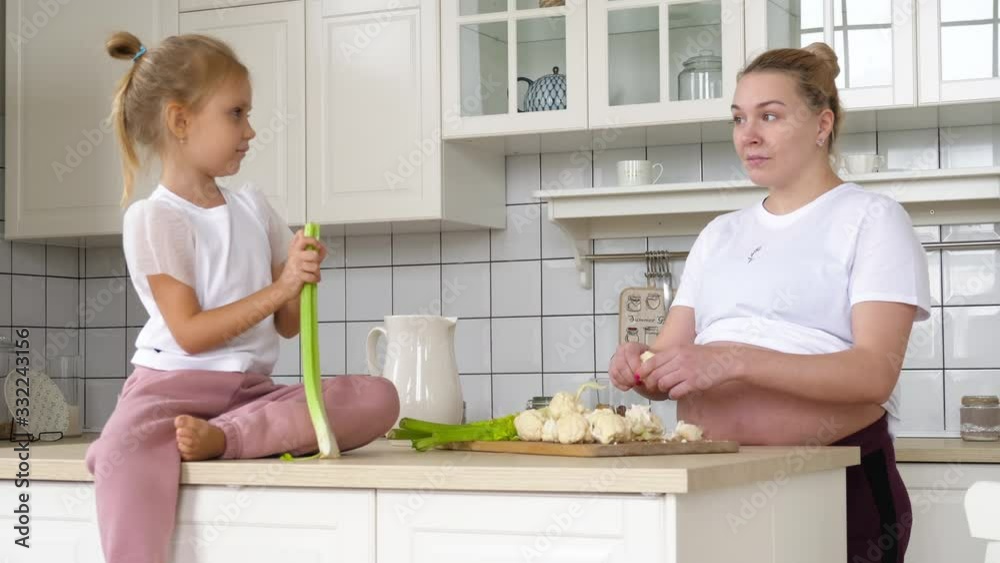 Second pregnancy family in the morning in the kitchen. A pregnant girl with a child is cooking dinner. The large family