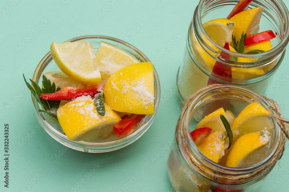 Fermented lemons with salt and chili pepper in jars.