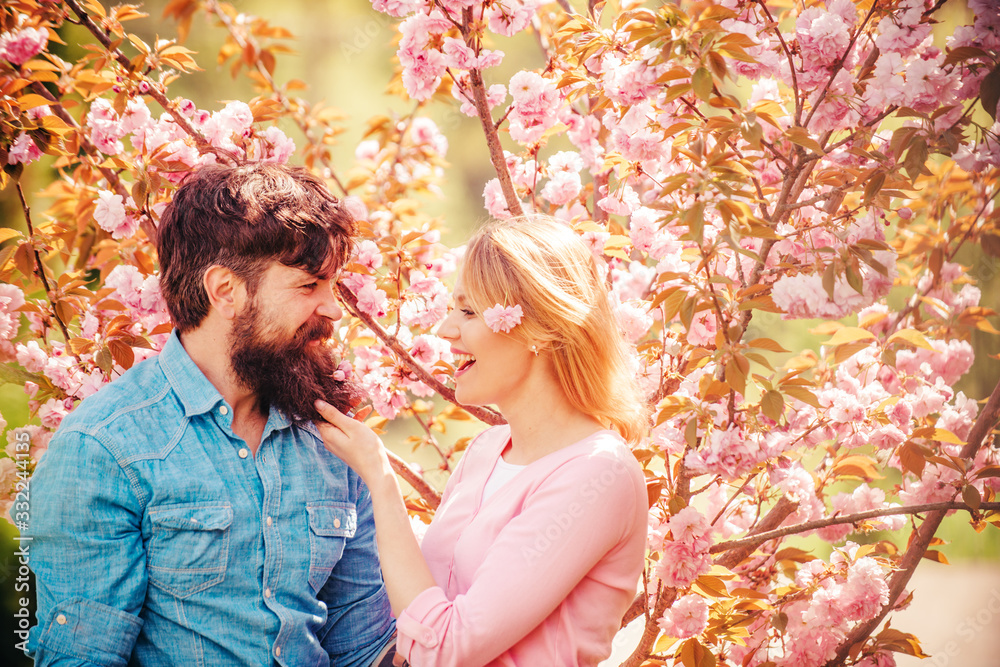 Young happy couple near blossom tree. Couple in sunny spring day. Romantic couple in love looking at each other. Happy easter. Young happy couple near blossom tree. Couple in sunny spring day. Romantic couple in love looking at each other. Happy easter.