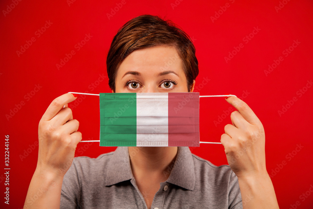 Coronavirus COVID-19 in Italy. Woman in medical protective mask with the image of the flag of Italy. Coronavirus COVID-19 in Italy. Woman in medical protective mask with the image of the flag of Italy.