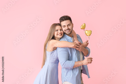 Happy young couple with hearts on color background