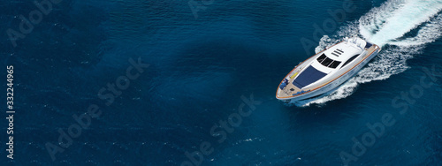 Aerial drone ultra wide photo of motor boat cruising in high speed in tropical exotic bay with emerald sea photo