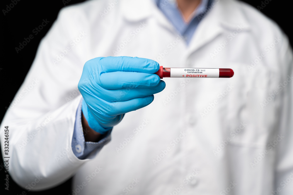 Doctor holds COVID 19 Coronavirus vaccine in his hand, infected blood sample in the sample tube, Vaccine and syringe injection It use for prevention, immunization and treatment from COVID-19
