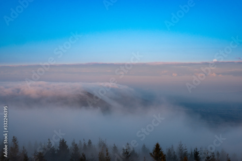 A roll of fog through the mountains into the valley at sunrise and sunset months