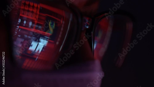 masked man in front of a computer ,the reflection in the glasses