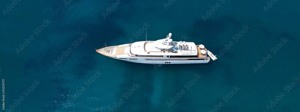 Aerial drone top down photo of luxury yacht with wooden deck anchored in open ocean sea - obrazy, fototapety, plakaty 