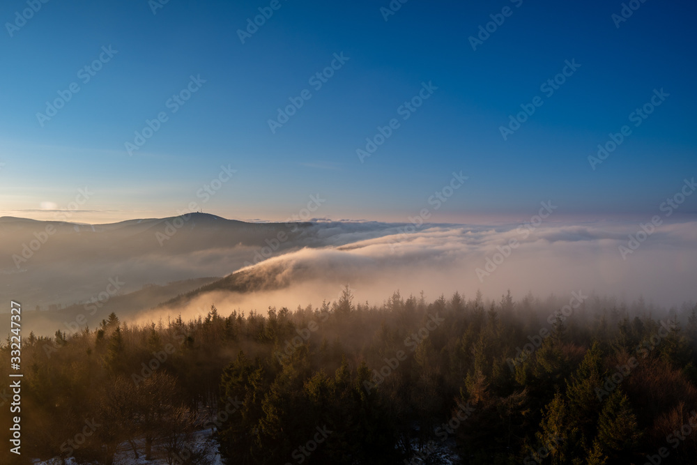 Sunrise in the mountains in spring with a roller with fog in the valley, morning in Czech Beskydy