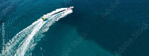 Aerial drone ultra wide photo of water skier cruising in high speed in tropical exotic bay