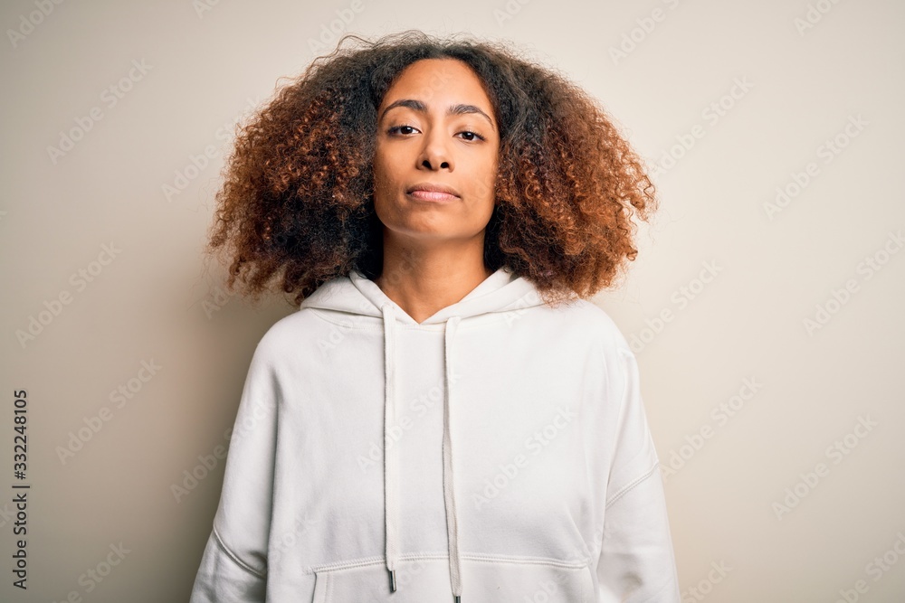 Young african american sportswoman with afro hair wearing sporty sweatshirt Relaxed with serious expression on face. Simple and natural looking at the camera.
