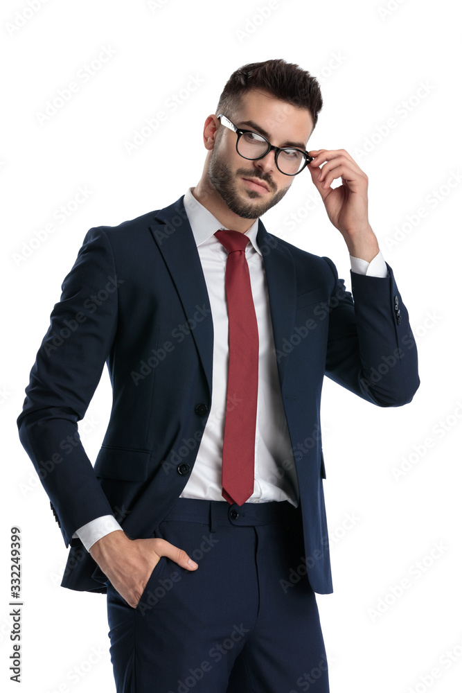businessman standing with hand in pocket and fixing glasses cool businessman standing with hand in pocket and fixing glasses cool