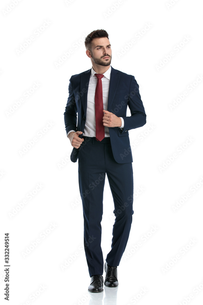 businessman walking while fixing jacket and looking away with attitude businessman walking while fixing jacket and looking away with attitude