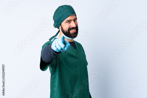 Surgeon man in green uniform over isolated background pointing front with happy expression