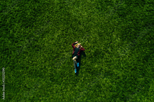 Happy woman relaxing on the grass. Aerial top view of vacation during sunny summer day