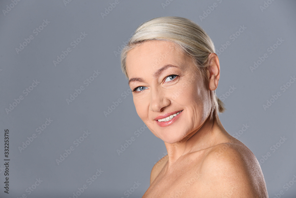 Portrait of beautiful mature woman on grey background. Space for text Portrait of beautiful mature woman on grey background. Space for text