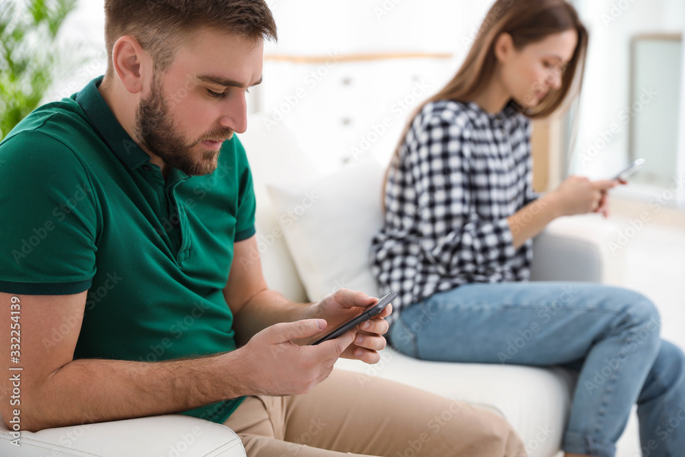 Couple addicted to smartphones ignoring each other at home. Relationship problems Couple addicted to smartphones ignoring each other at home. Relationship problems