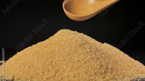 Cane sugar unrefined. A heap of sugar is mixed with a wooden spoon. photo