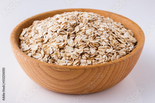 raw oat flakes on white acrylic background
