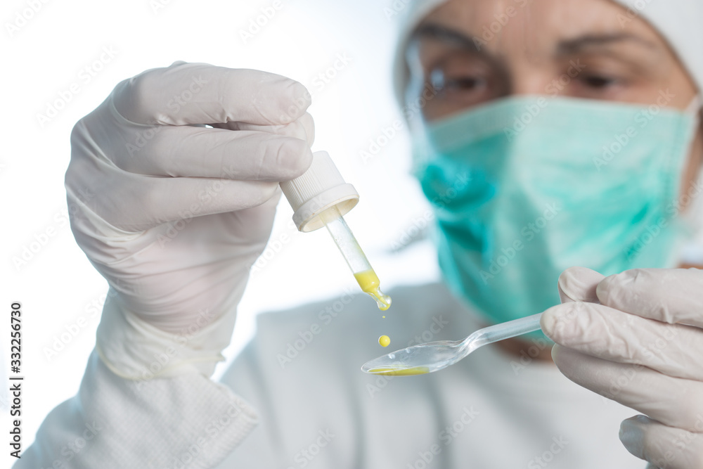 The doctor prepares an oral vaccine with pipette and spoon