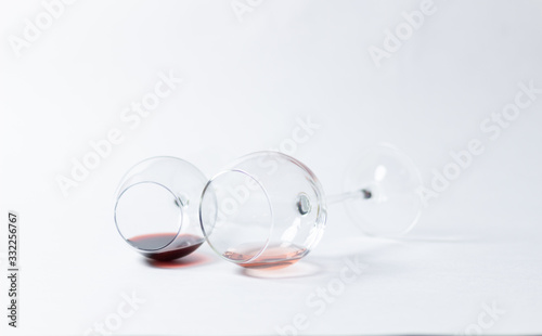 Glasses with red and pink wine laying on white background