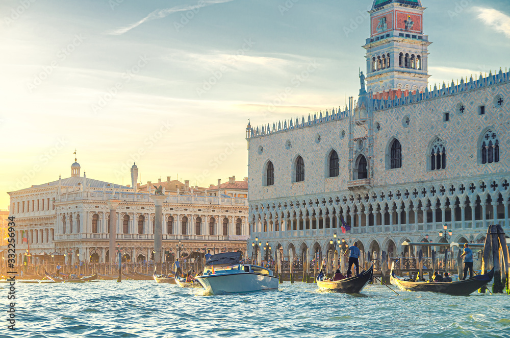 Venice cityscape with gondolas and yacht boats on water of San Marco basin, Riva degli Schiavoni waterfront promenade, Doge's Palace Palazzo Ducale Venetian Gothic style building, Veneto Region, Italy