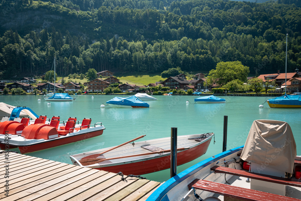 Boats and catamarans on the pier, boat rental for tourists on a lake. A picturesque place for a relaxing holiday.