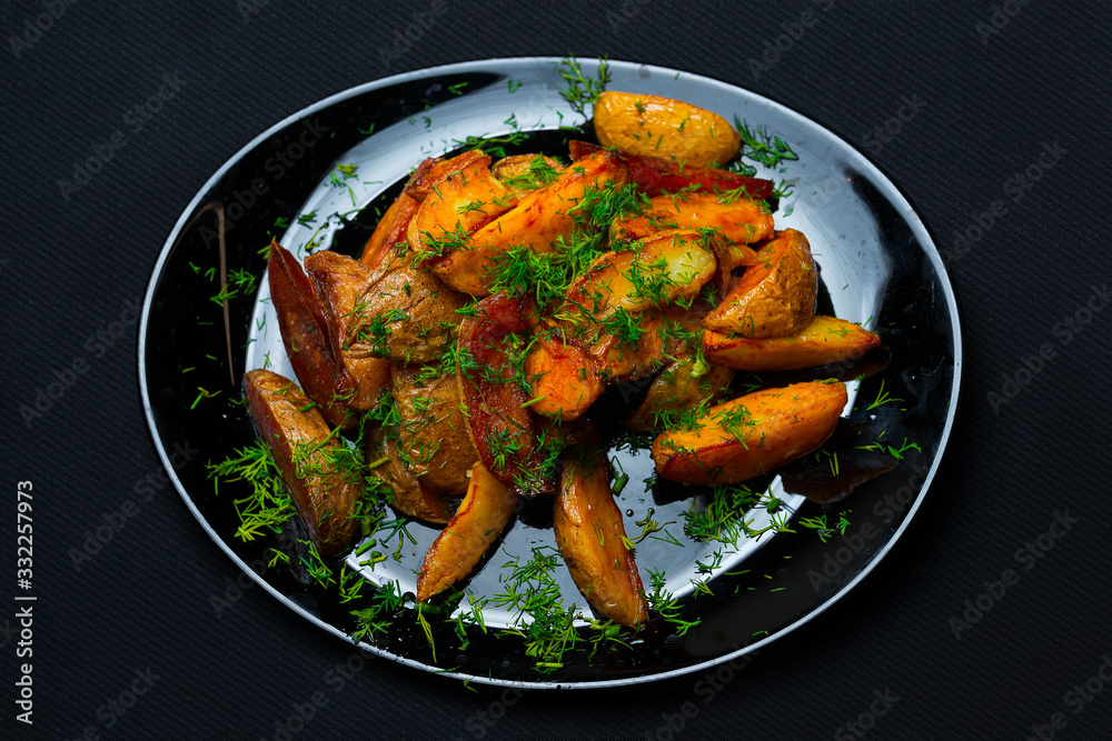 Fototapeta premium rural potatoes in a plate on a dark background. Top view. Place for text.