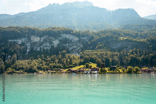 View over the lake at with mountains in the background. Houses on the shore of a picturesque lake.