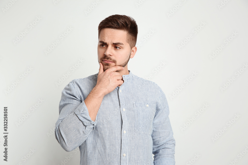 Pensive man on light background. Thinking about answer for question Pensive man on light background. Thinking about answer for question