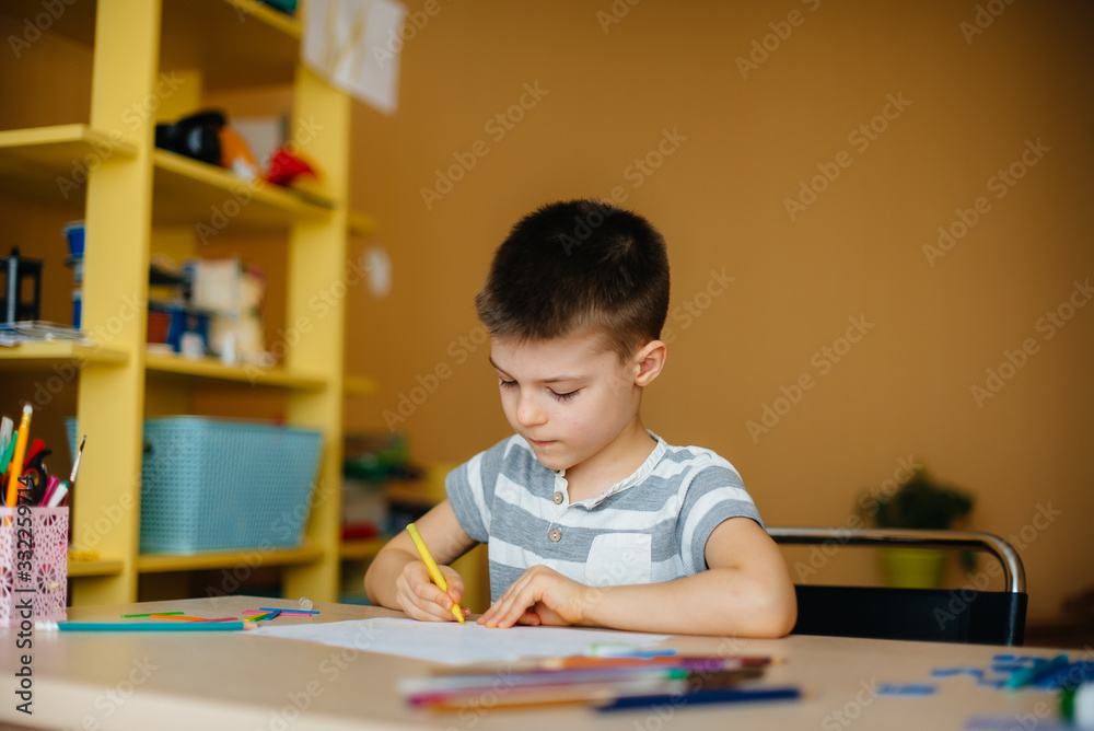 A school-age boy does homework at home. Training at school A school-age boy does homework at home. Training at school