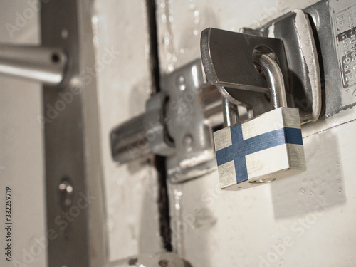 A bolted door secured by a padlock with the national flag of Finland on it.(series) photo