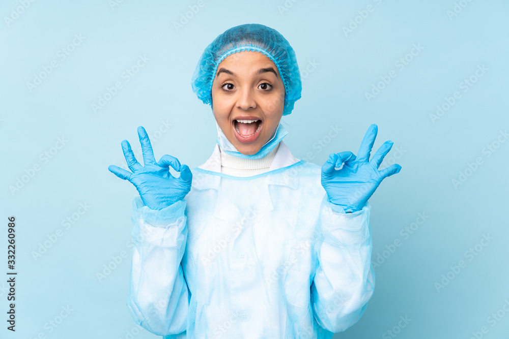 Young surgeon Indian woman in blue uniform showing an ok sign with fingers Young surgeon Indian woman in blue uniform showing an ok sign with fingers