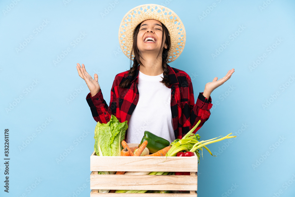 Young farmer Woman holding fresh vegetables in a wooden basket smiling a lot