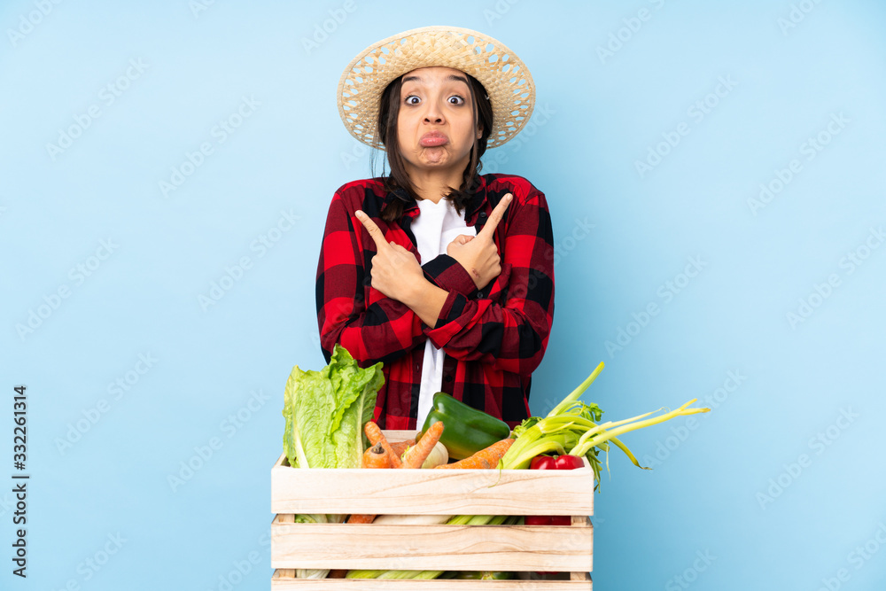 Young farmer Woman holding fresh vegetables in a wooden basket pointing to the laterals having doubts