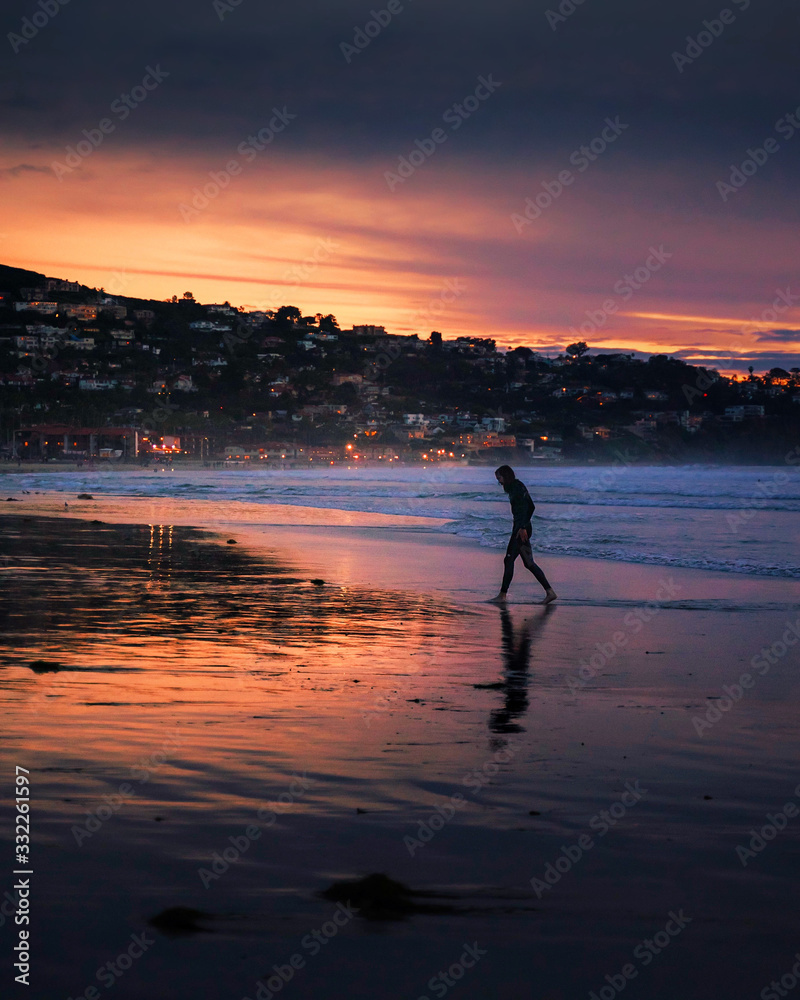Man Walking Out of Ocean at Sunset