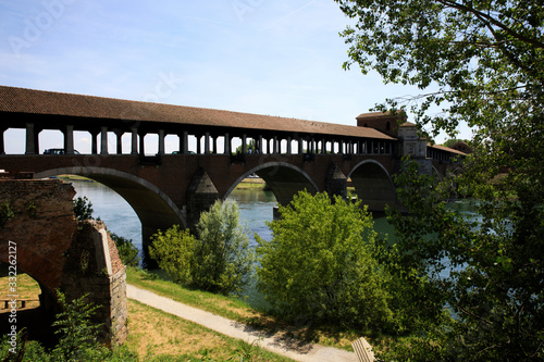 Pavia (PV), Italy - June 09, 2018: The Ponte Coperto (covered bridge), also known as the Ponte Vecchio (old bridge), a brick and stone arch bridge over the Ticino River in Pavia, Lombardy, Italy