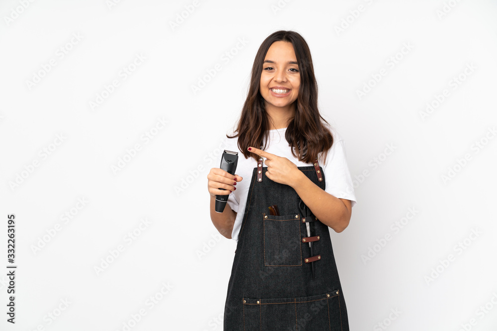 Young hairdresser woman isolated on white background pointing to the side to present a product Young hairdresser woman isolated on white background pointing to the side to present a product