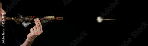 Blowpipe (blowgun) and darts from indegenous tribe of Amazon (near Manaus) isolated on black background