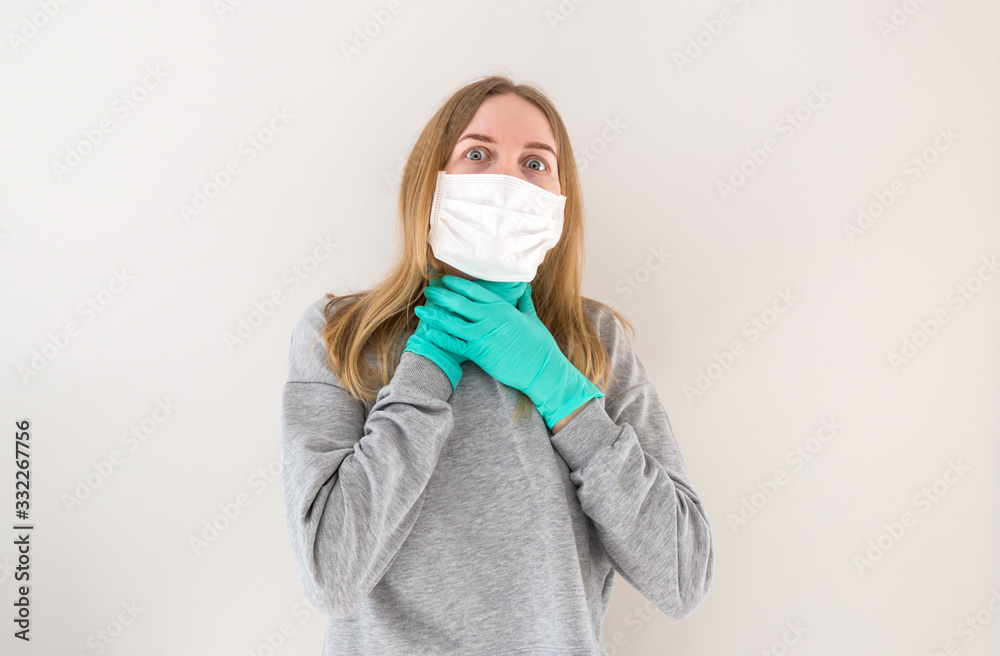 Portrait of blonde woman holding her inflamed throat or tonsillitis. The concept of the epidemic of the coronavirus and anti-smog. Air pollution, contagious disease, virus infection.
