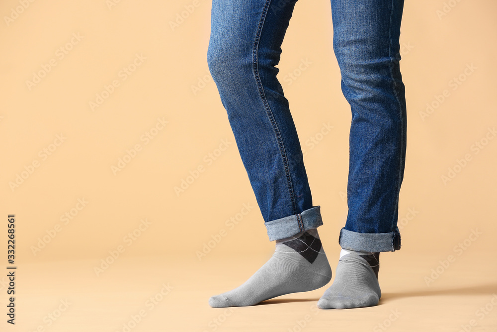 Male legs in socks and jeans on color background Male legs in socks and jeans on color background
