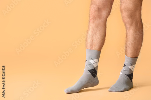 Male legs in socks on color background