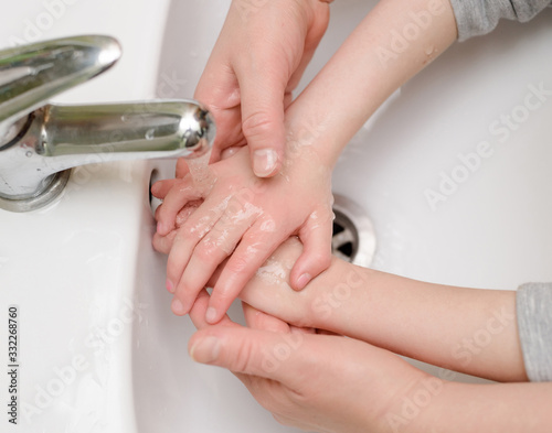 child washes hands in bathroom
