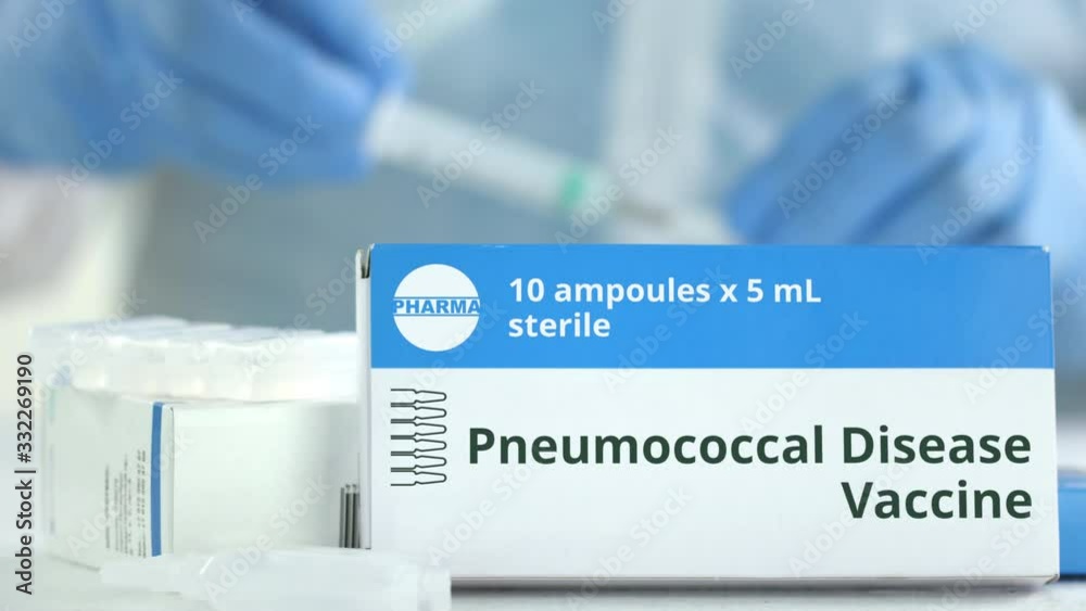 Box with pneumococcal disease vaccine on the table against blurred lab assistant. Fictional phaceutical logo Box with pneumococcal disease vaccine on the table against blurred lab assistant. Fictional phaceutical logo