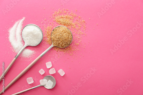 Spoons with sweet sugar on color background