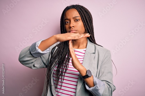 Young african american business woman standing over pink isolated background Doing time out gesture with hands, frustrated and serious face